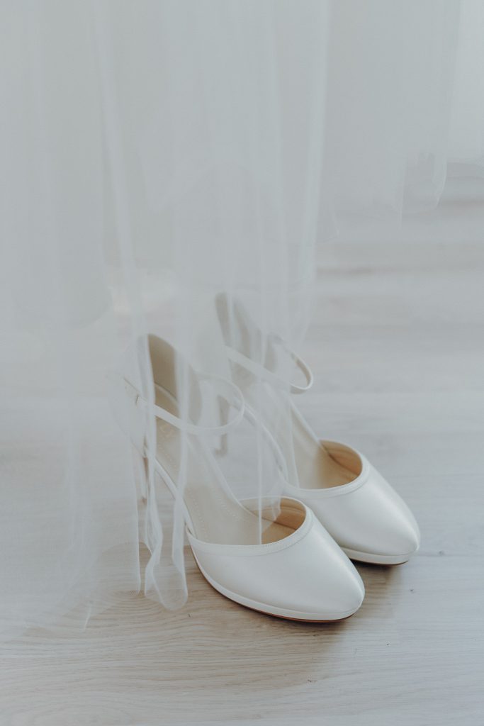 Weiße Hochzeitsschuhe auf Boden